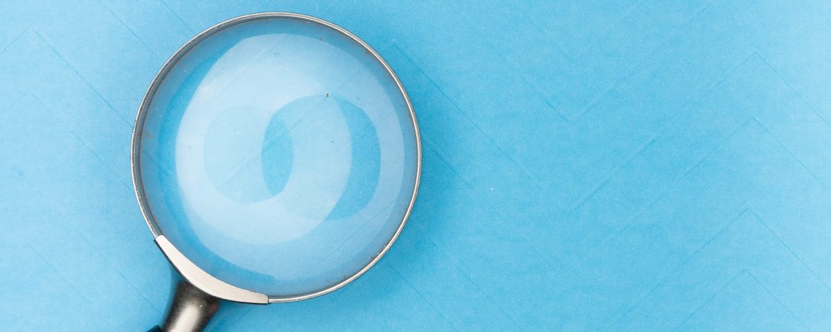 Magnifying glass rests on light blue background