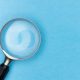 Magnifying glass rests on light blue background